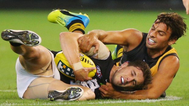 Getting down but not dirty: Sam Lloyd of the Tigers tackles Marc Murphy of the Blues.