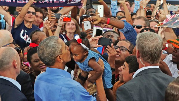 President Barack Obama kisses a young child during a campaign event in the key state of Florida on November 6.