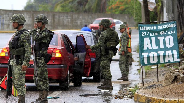 Soldiers inspect a vehicle at a checkpoint in Acapulco, Mexico on Sunday after news of El Chapo's escape. 