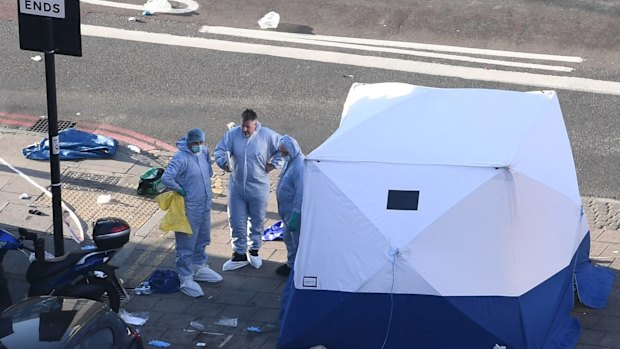 Forensics officers examine the crime scene on Monday morning.