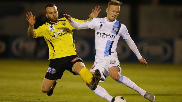 Reuben Way of Heidelberg United and Jack Clisby of Melbourne City compete for the ball.