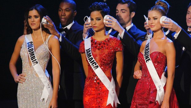 Hear no evil ... Miss Colombia Paulina Vega, the eventual winner of the contest, Miss Jamaica Kaci Fennell, and Miss Ukraine Diana Harkusha have their hearing muffled during the contest's question time.