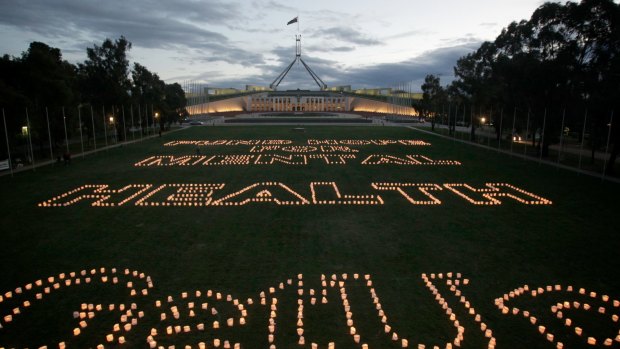 Thousands of candles are lit on the lawns of Parliament House by GetUp! members spelling the words "FUND HOPE FOR MENTAL HEALTH".
