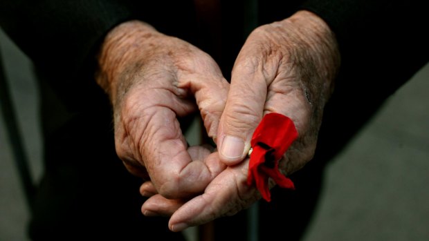 A WWII veteran holds a poppy at the Cenotaph on Anzac Day, 2009.
