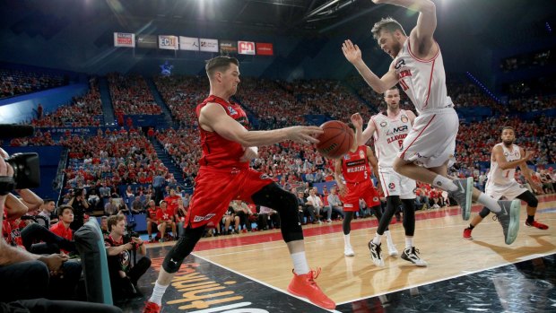 Lucas Walker (left) of the Wildcats keeps the ball in play as Nick Kay of the Hawks attempts a block at Perth Arena on Friday night.
