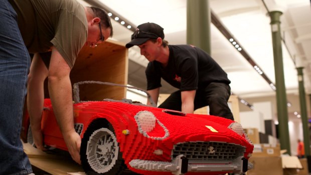 Professional Lego builder Ryan McNaught, left, with his bright red Ferrari. 