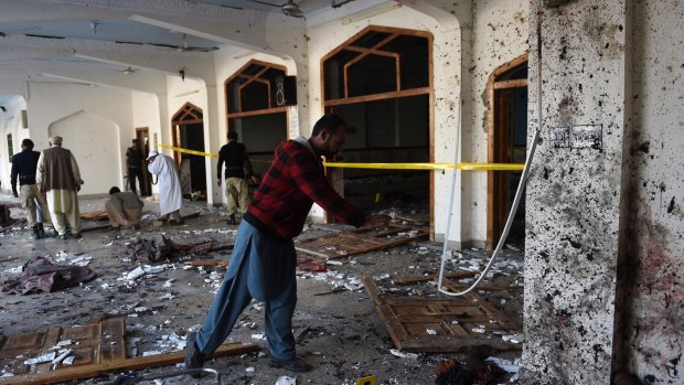 Pakistani security personnel inspect a Shiite mosque after the attack by Taliban militants in Peshawar.