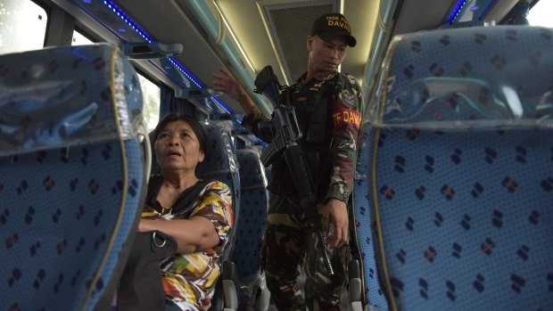 Philippines police and soldiers conduct vehicle searches at a checkpoint in the southern city of Davao.