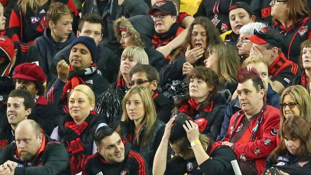 Downcast: Bombers fans look dejected as the Lions kick ahead.