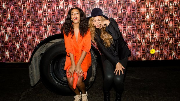 Solange Knowles (L) and Beyonce Knowles pose for a photo against the bounce bus at the cocktail reception for "Amen Amen! The 17 Wards of Wonder" a multidisciplinary art experience in celebration of prospect. 3 on October 26, 2014 in New Orleans, Louisiana. 