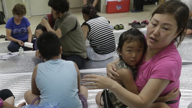 South Korean residents gather at a shelter in Yeoncheon, where the shell fell on Thursday.