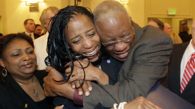 Mia Love is embraced by her father, Jean Maxime Bourdeau, in Salt Lake City after winning her seat in Congress.