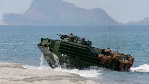 A US Navy amphibious assault vehicle with Philippine and US troops storms a beach opposite one of the disputed South China Sea islets.