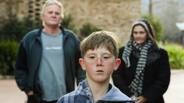 Jack Hartigan, now aged 11, has filed civil action against the ACT Government after he was mauled by dogs. He is with his parents, Patrick Hartigan and Joanne Mangan.