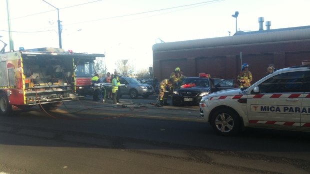 Firefighters work to free a person from a car at the intersection of Spencer and La Trobe streets.