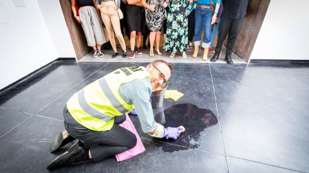 Adam Bandt cleaning the floor of ACCA as part of artist Nat Thomas' installation 'Man Cleaning Up'. 