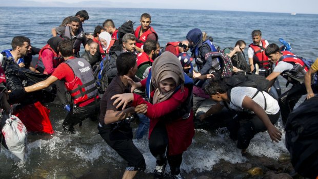 Migrants and refugees arrive on a dinghy after crossing from Turkey to Lesbos island, Greece.