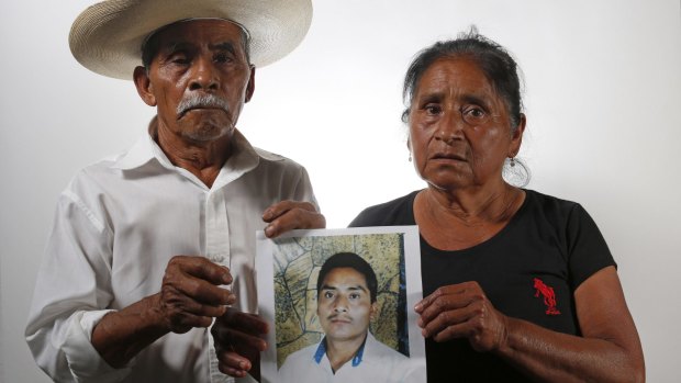 Matias Fermin Montano, left, and Agustina Ramirez Nemesio, hold up a photo of their missing son, Margarito Fermin Ramirez in Iguala, Mexico. Their son disappeared in 2012, one of the many referred to as the "other disappeared".