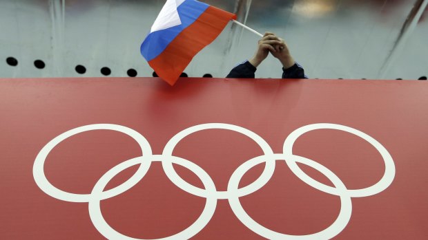 A Russian flag flutters over the Olympic rings at the 2014 Winter Games in Sochi.