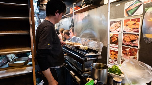 A chef grills meat skewers at an izakaya in Tokyo's Shibuya district.