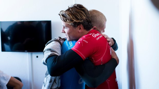 Ordeal over: Julian Wilson hugs Mick Fanning from the safety of shore.