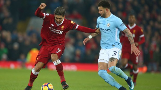 Liverpool's Roberto Firmino and Manchester City's Kyle Walker vie for the ball.