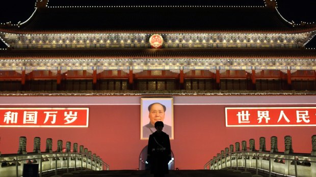 A paramilitary police officer stands guard in front of a portrait of former Chinese leader Mao Zedong at Tiananmen Gate.