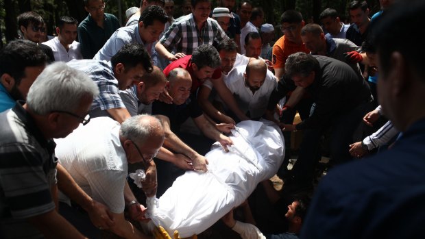 The coffin of airport taxi driver Mustafa Biyikli is buried in Istanbul.