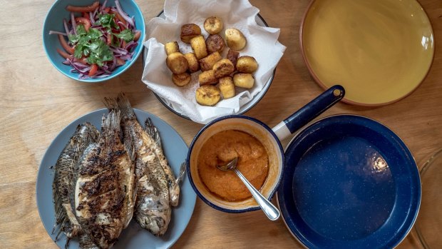 Whole tilapia with browned plantains, homemade hot sauce and a salad of onions, tomatoes and herbs from Flavour: Eat What You Love.