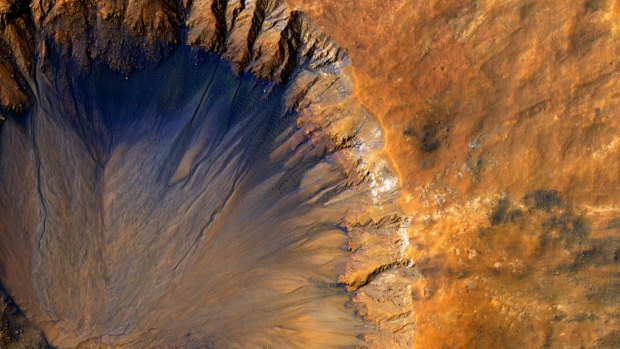 A close-up of an impact crater on Mars. The glass spotted inside could contain signs of long-ago life.