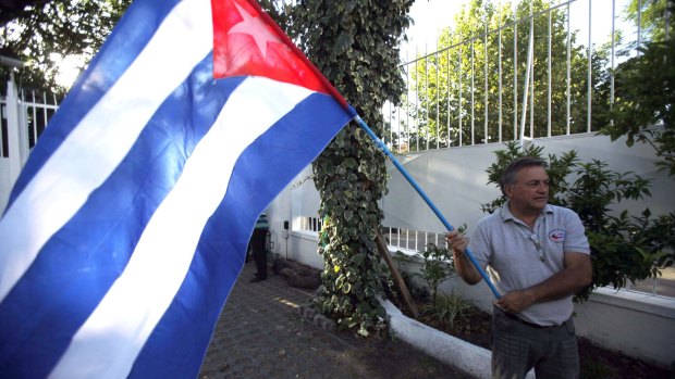 A man in Havana waves a Cuban flag while celebrating the restoration of diplomatic relations with the US.