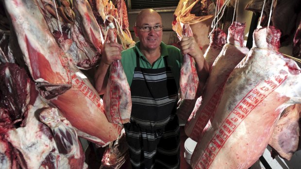 Queanbeyan butcher Peter Linbeck in the cold storage room with lamb trunks and legs.