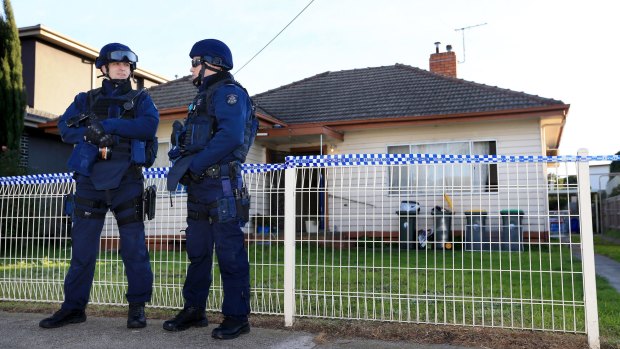 Heavily armed police guard a house in Pascoe Vale on Tuesday morning.