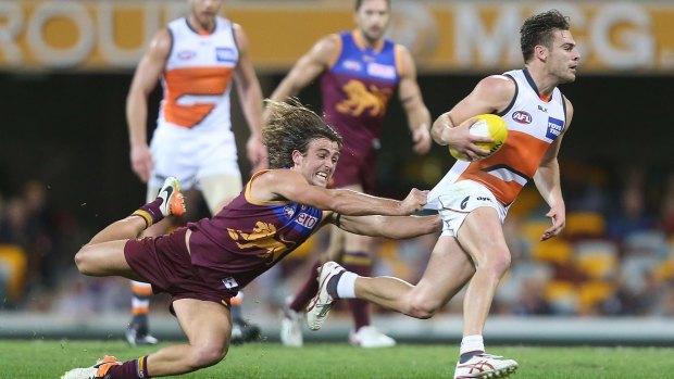 Sums it all up: Giant Stephen Conigliois is just beyond the reach of Brisbane's Rhys Mathieson on Sunday night at the Gabba.