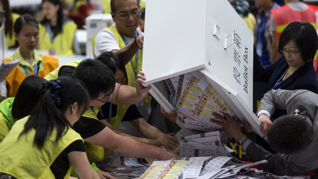 Officials empty ballot papers for the Legislative Council election  in Hong Kong.