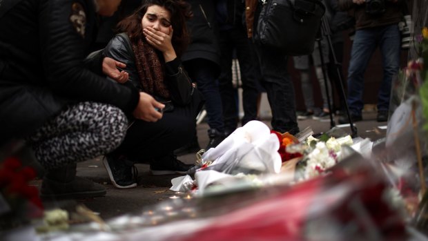 A woman places flowers near the scene of the Bataclan Theatre terrorist attack.