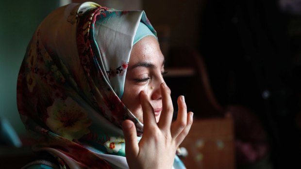 Alaa, 19, who was shot in March 2013 in her jaw during clashes between Syrian government forces and rebels  in the Syrian province of Homs, wipes tears as she tells her  story in Bebnine town, northern Lebanon. 