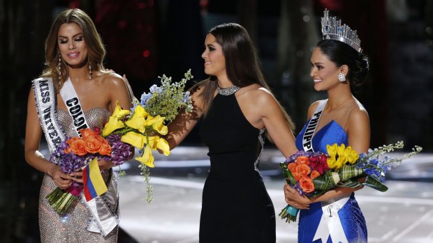Former Miss Universe Paulina Vega, centre, takes away the flowers and sash from Miss Colombia Ariadna Gutierrez, left, before giving them to Miss Philippines Pia Alonzo Wurtzbach, right, at the 2015 Miss Universe pageant.
