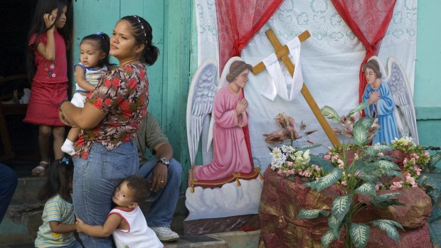 A family watches a  procession during Semana Santa.