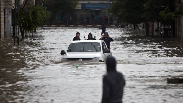 Storm aftermath: Residents make their way through a flooded street in Gaza City.