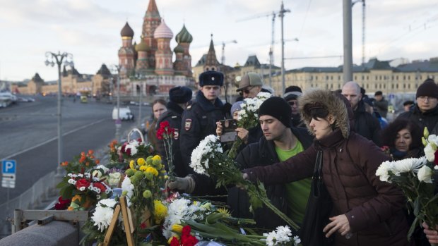 People lay flowers near the spot where  Boris Nemtsov was gunned down a year ago in Moscow.