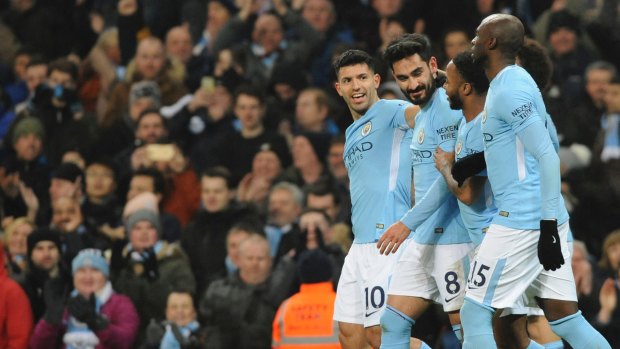 Manchester City players celebrate their team's first goal.