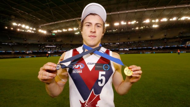 Sandringham's Andrew McGrath holds his best on ground and premiership medals.