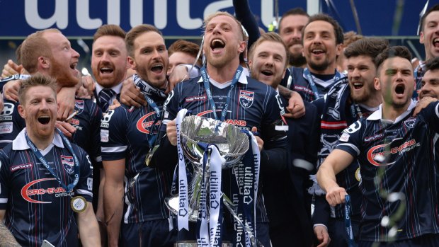 Andrew Davies of Ross County lifts the League Cup trophy.