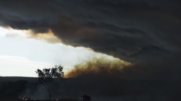Farmers battle a lightning strike fire which was started by the mammoth blaze west of Cassilis.