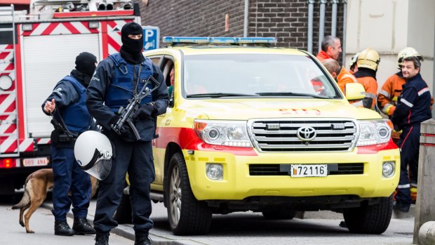 Armed police guard a street in the Brussels neighbourhood of Molenbeek amid a manhunt for a suspect of the Paris attacks.