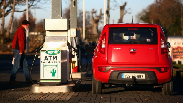 A customer returns to his Irish number-plated car at a petrol station near Newry in Northern Ireland.