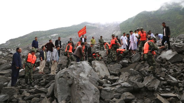 Emergency personnel work at the site of a landslide in Xinmo village on Saturday.
