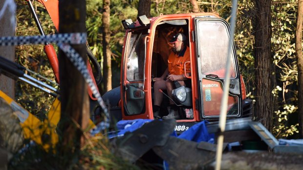 A man operates the digger at the scene in the Royal National Park at Waterfall where Matthew Leveson's remains were unearthed.