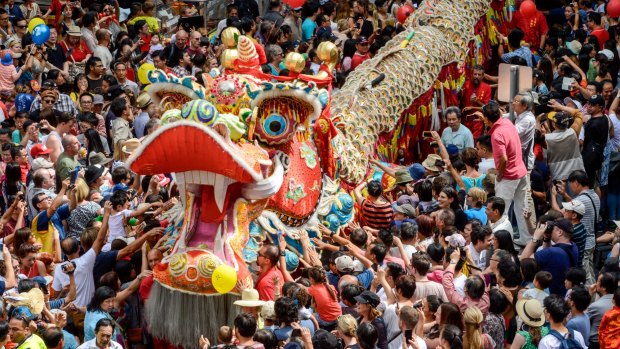 Chinese New Year revellers reach out to touch Dai Loong (Big Dragon) for good luck as it makes it's way along Russel Street.